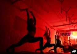 FILE - Women attend a yoga master class at Shogun sports center in Kyiv, Ukraine on Nov. 29, 2024. (AP Photo/Evgeniy Maloletka)