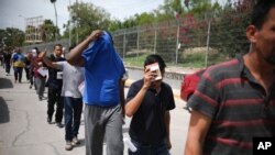 FILE - Migrants return to Mexico, using the Puerta Mexico bridge that crosses the Rio Grande river in Matamoros, Mexico, on the border with Brownsville, Texas, July 31, 2019. 