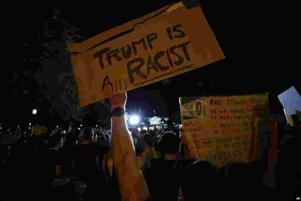 នៅក្នុង​បាតុកម្ម​នៅ​ថ្ងៃសៅរ៍ ទី ៣០ ខែឧសភា ឆ្នាំ ២០២០ ក្បែរ​សេតវិមាន​ក្នុង​រដ្ឋធានី​វ៉ាស៊ីនតោន បាតុករ​ម្នាក់ កាន់​ស្លាក​សញ្ញា​ដែល​សរសេរ​ថា &laquo;លោក ត្រាំ ជា​អ្នក​ប្រកាន់​ពូជសាសន៍​ពណ៌សម្បុរ&raquo; ដើម្បី​ជា​ការតវ៉ា​អំពី​ការស្លាប់​របស់​លោក George Floyd នៅ​ថ្ងៃសៅរ៍​ទី ៣០ ខែឧសភា ឆ្នាំ ២០២០ ក្បែរ​សេតវិមាន​ក្នុង​រដ្ឋធានី​វ៉ាស៊ីនតោន។&nbsp;(AP) 