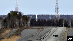 A Russian Soyuz rocket, center in the background, carrying satellites stands on the launch pad at the new Vostochny Cosmodrome near Uglegorsk, the city in eastern Siberia in the Amur region, Russia, April 27, 2016. 