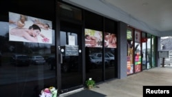Flowers are seen laid in front of the Young's Asian Massage following the deadly shootings in Acworth, Georgia, March 17, 2021. 
