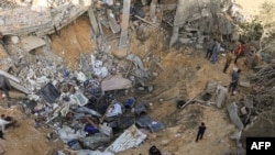 Palestinci stoje na rubu kratera nakon izraelskog bombardiranja Rafaha u južnom pojasu Gaze 10. novembra 2023.