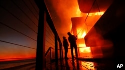 ကယ်လီဖိုးနီးယားပြည်နယ် မာလီဘူမြို့မှာ မီးလောင်နေတဲ့အဆောက်အဦးကို မီးငြိမ်းနေတဲ့ မီးသတ်ဝန်ထမ်းများ။ (ဇန်နဝါရီ ၈၊ ၂၀၂၅)