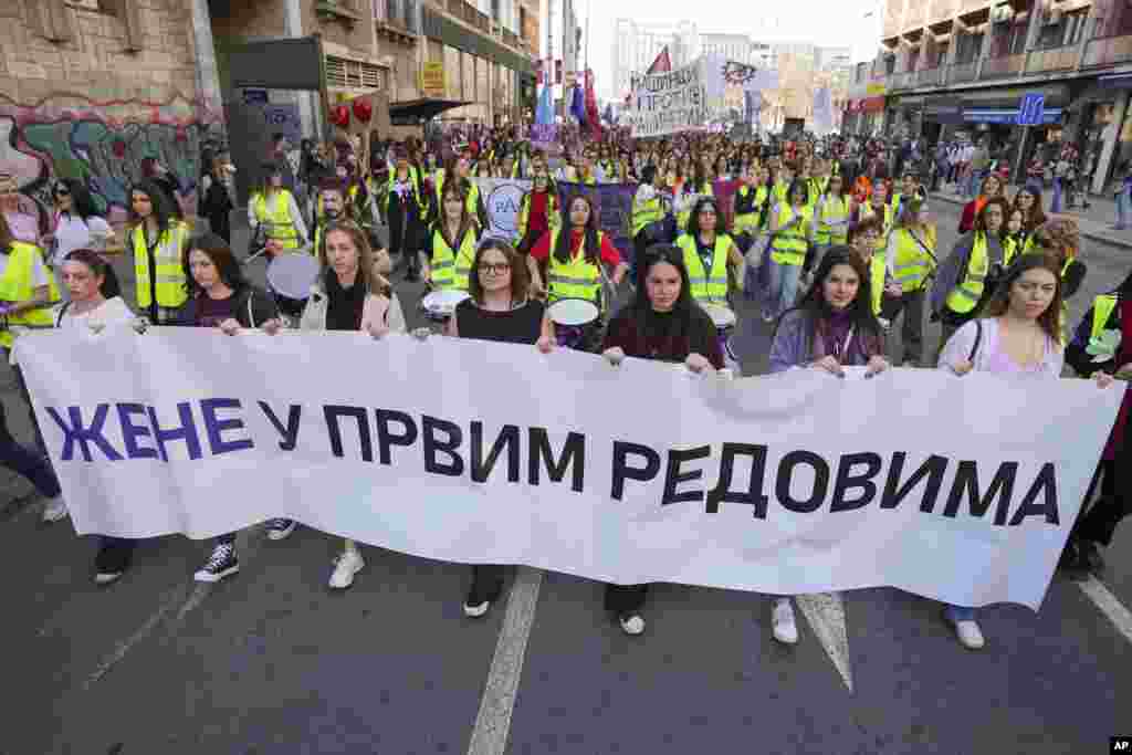 Mujeres sostienen una pancarta que dice: "Mujeres en las primeras filas" durante una marcha en apoyo a las mujeres en el Día Internacional de la Mujer en Belgrado, Serbia, el sábado 8 de marzo de 2025. (Foto AP/Darko Vojinovic)