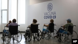 Jubilados esperan en sillas de ruedas en el área de observación, luego de recibir la segunda dosis de la vacuna SINOVAC COVID-19 en un centro de vacunación en San Salvador, El Salvador, el martes 22 de junio de 2021.