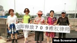 中国维权人士6月12日在北京举牌要求当局释放709律师(参与网图片)