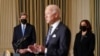El presidente Joe Biden, en primer plano, se dirige a los periodistas, en presencia de la vicepresidenta Kamala Harris y del enviado presidencial especial para el Cambio Climático de la Casa Blanca, John Kerry, en la Casa Blanca, el 27 de enero de 2021.