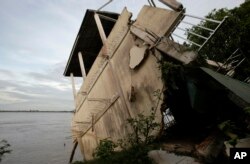 ឯកសារ៖ ផ្ទះ​មួយ​ដែល​ត្រូវ​ខូចខាត​ដោយ​ទឹក​ជំនន់​ទោរ​ចូល​ទន្លេ​មេគង្គ​ត្រង់​ចំណុច​ភូម​នរា​នៅ​រាជធានី​ភ្នំពេញ​កាល​ពី​ឆ្នាំ​២០១១។