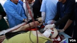 En primer plano el fotógrafo Chris Hondros, cuando era retirado herido de gravedad tras el ataque que le causó la muerte horas después.