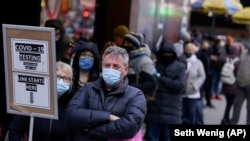 FILE - People wait in line at a COVID testing site in NYC on Dec. 13, 2021. (AP Photo/Seth Wenig, File)