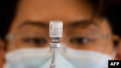 (FILES) In this file photo taken on May 14, 2021, a health care worker prepares a dose of the Pfizer Covid-19 vaccine at a Los Angeles County mobile vaccination clinic in Los Angeles