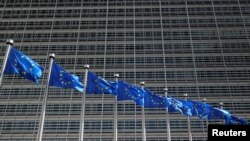 FILE - European Union flags flutter outside the EU Commission headquarters in Brussels, Belgium June 20, 2018.