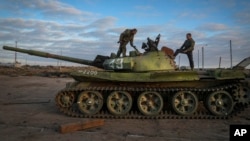 Ukrainian soldiers inspect a damaged Russian tank in the recently retaken village Chornobaivka near Kherson, Ukraine, Tuesday, Nov. 15, 2022. (AP Photo/Efrem Lukatsky)