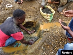 FILE - An artisanal miner washes tin ore before it is bagged up and weighed, ready to be transported to the nearest major town for export in the Kalimbi tin mine near the small town of Nyabibwe, Democratic Republic of the Congo.