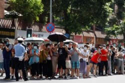 成都民众聚集在美国驻成都总领事馆外观看领馆人员撤离。（2020年7月26日）