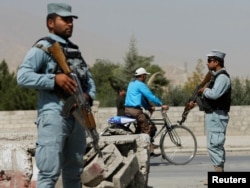 Afghan policemen stand guard at a checkpoint near the site of kidnapping in Kabul, Aug. 8, 2016.