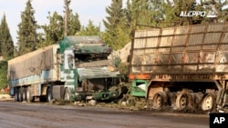 An image provided by the Syrian anti-government group Aleppo 24 news, shows damaged trucks carrying aid, in Aleppo, Syria, Sept. 20, 2016. The U.S. says evidence points to Russia as being responsible for the bombing of the convoy.