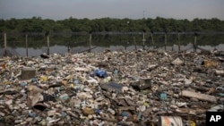 In this May 15, 2014 photo, trash floats on a polluted waterway that flows into the Guanabara Bay in Rio de Janeiro, Brazil. 