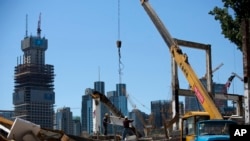 កម្មករ​កំពុង​រំកិល​ដែកនៅ​ឯការដ្ឋាន​ខូចខាត​មួយ​ ដើម្បី​ចាប់ផ្តើម​គម្រោង​អភិវឌ្ឍន៍ថ្មី​​ នៅ​ក្នុង​សង្កាត់​មួយ​នៃ​ទីក្រុង​ប៉េកាំង ប្រទេស​ចិន កាលពីថ្ងៃទី៣០ ខែ​មិថុនា ឆ្នាំ២០១៥។