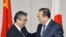 日本副外相杉山晋輔（左）与中国副外长刘建超3月19日在东京会谈前握手