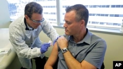 Farmaceut Majkl Vite daje injekciju Nilu Brauningu u Sijetlu, u okviru prve faze testiranja nove vakcine za koronavirus (Foto: AP/Ted S. Warren)