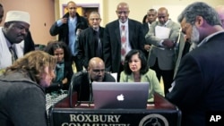 FILE - Muslim, Christian, minority and government leaders fix their eyes on a laptop screen showing a video as part of the Countering Violent Extremism program at Roxbury Community College in Boston, March 31, 2015. 