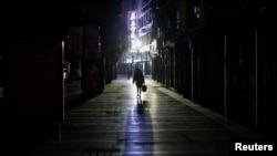 2020年2月1日，江西九江一女子走过一条寂静的商业街。由新型冠状病毒导致的武汉肺炎疫情仍在中国肆虐。（路透社）