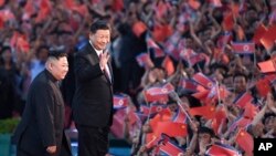 На архівному фото - лідер Північної Кореї Кім Чен Ин (ліворуч) і президент Китаю Сі Цзіньпін (справа) відвідують масову гімнастичну виставу на стадіоні в Пхеньяні, Північна Корея, у 2019 році. Yan Yan/Xinhua via AP