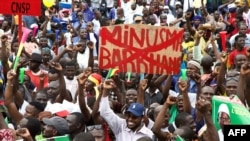 FILE - A man holds a banner against the United Nations Multidimensional Integrated Stabilization Mission in Mali and Barkhane, an operation led by the French military against Islamist groups in Africa's Sahel region, in Bamako, Mali, Aug. 21, 2020. 
