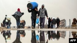 Banorët e Gazës të ngarkuar me sende kalojnë pranë urës në qytetin e Gazës më 10 shkurt, 2025 ndërkohë që kthehen në shtëpitë e tyre gjatë periudhës së armëpushimit me Izraelit dhe Hamasit/AFP