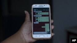 In this Monday, June 15, 2020 photo, Rafaela Matos shows the last text messages from her son João Pedro Matos Pinto, at her home in Sao Goncalo, Brazil. (AP Photo/Silvia Izquierdo)