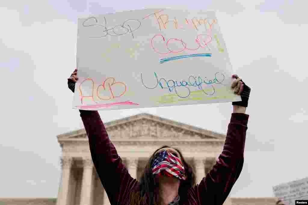 Una activista que se opone a la nominación de Amy Coney Barrett a la Corte Suprema sostiene un cartel que dice "Detengan el Golpe de Trump" en la Corte Suprema en Washington, D.C., el lunes 26 de octubre de 2020.