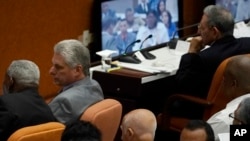 Miguel Diaz-Canel, second left, talks to another person during the start of two-day session of the legislature, in Havana, Cuba, Wednesday, April 18, 2018. Cuba's legislature opened the two-day session that is to elect a successor to President Raul Castro, at right. (AP Photo/Ramon Espinosa)