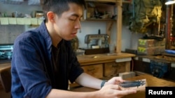 Kevin Cheung, an upcycling product designer, holds a "Glory to Hong Kong" thumb piano that he made using the ribs of umbrellas left over from protests this summer, in Hong Kong, China November 20, 2019. Picture taken November 20, 2019. REUTERS/Sarah Wu