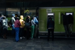 People queue for cash at an ATM which dispensed the new Zimbabwean ten-dollar notes, in Harare, May 20, 2020. The higher denomination bank note was introduced to help ease perennial shortages of cash in the country.