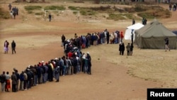 Zimbabweans wait in line to cast their votes in Mbare township outside Harare, July 31, 2013.