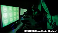 រូបឯកសារ៖ បុរស​បីនាក់​​ កំពុង​តែ​មើល​​កុំព្យូទ័រ​​​ នៅ​ថ្ងៃទី២៧ ខែធ្នូ ឆ្នាំ២០១៤។