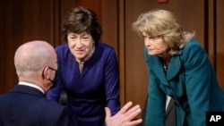 Homeland Security Secretary Alejandro Mayorkas, left, talks with Sen. Susan Collins, R-Maine, center, and Sen. Lisa Murkowski, R-Alaska, right, during a break of the Senate Appropriations committee hearing to examine domestic extremism, Wednesday,…