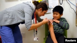FILE - A boy gets an influenza vaccine injection at a health care clinic, in Boston, Massachusetts, Jan. 12, 2013.