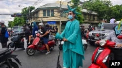 FILE - A pro-democracy protester dressed as the Statue of Liberty rides an electric scooter during an anti-government demonstration marking the anniversary of the 1932 Siamese Revolution in Bangkok, Thailand, June 24, 2021.