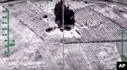 In this photo made from video footage provided by the Russian Defense Ministry on Dec. 9, 2015, a target is hit during an airstrike. Russia has unleashed another barrage of airstrikes against targets in Syria, including the first combat launch of a new cruise missile from a Russian submarine in the Mediterranean Sea.