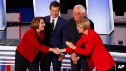 Demokratlar partiyasidan prezidentlikka ayol nomzodlar - Eymi Kloubushar (chapda) va Elizabet Uorren qo'l berib ko'rishmoqda.