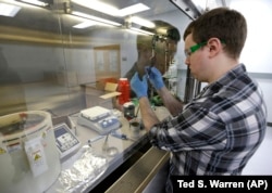 Caleb Ogier, a PhD student in mechanical engineering at the University of Washington, works in a fume hood with ink used to produce electrical circuits, at the newly opened Washington Clean Energy Testbeds laboratory.