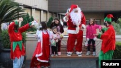 FILE PHOTO A man dressed as Santa Claus, entertains children at Beirut Souks, in downtown Beirut, Lebanon December 19, 2020. (REUTERS/Mohamed Azakir)