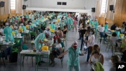 FILE - Teachers and auxiliary staff take COVID-19 tests in Madrid, Spain, Sept. 2, 2020.