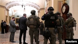 Police with the Alcohol, Tobacco and Firearms (ATF) maintain security in the halls of the Senate in the U.S. Capitol, as a joint session continues in the House to certify President-elect Joe Biden, in Washington, Jan. 6, 2021. 