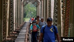 Un grupo de migrantes hondureños caminan por la vía del tren de camino a Estados Unidos en Huimanguillo, Tabasco, México, el 30 de marzo de 2021.