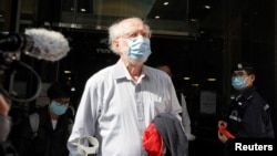 American lawyer John Clancey walks out of a building as he is taken away by police officers in Hong Kong, China January 6, 2021. REUTERS/Lam Yik