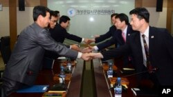 In this photo released by Unification Ministry, South Korean delegates, right, shake hands with their North Korean counterparts at Kaesong Industrial District Management Committee meeting, Kaesong, North Korea, Sept. 11, 2013.