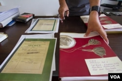 លោក ឆាំង យុ ប្រធាន​មជ្ឈមណ្ដល​ឯកសារ​កម្ពុជា​សើរើ​ឯកសារ​សម្ងាត់​ដែល​បរិច្ចាគ​ដោយ​ក្រសួង​ការបរទេស​អូស្ត្រាលី ​នៅក្នុង​ការិយាល័យ​របស់​លោក​កាលពី​ថ្ងៃទី ២២ខែ កញ្ញា ឆ្នាំ ២០១៥។ (នៅ វណ្ណារិន/VOA)